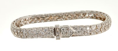 Lot 460 - Diamond bracelet with an articulated tapered band of pavé set brilliant cut diamonds, the stylised buckle clasp with princess cut diamonds. 17½cm length. Estimated total diamond weight approximatel...