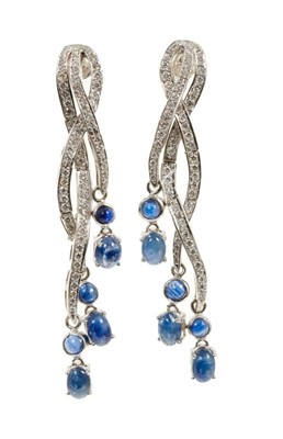 Lot 489 - Pair of diamond and sapphire pendant earrings with blue sapphire cabochons suspended from three articulated interwoven bands of brilliant cut diamonds, all in 18ct white gold setting. 68mm length.