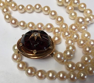 Lot 161 - Cultured pearl two strand necklace with a Victorian carved garnet and old cut diamond cluster