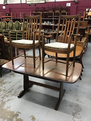 Lot 930 - An Ercol extending dining table and two matching elbow chairs with loose cushions