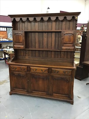 Lot 893 - Reproduction elm two height dresser with panelled doors and three drawers on bracket feet