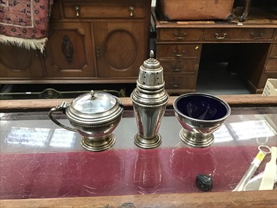 Lot 661 - Sterling silver cruet set, comprising a mustard pot, pepper and salt, with blue glass liners