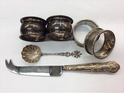 Lot 677 - Four silver napkin rings, silver handled cheese knife and a white metal caddy spoon