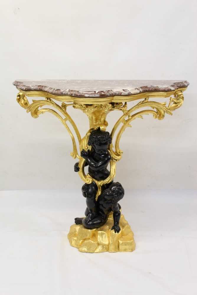 Lot 1226 - Decorative gilt and ebonised pier table with shaped rouge marble top supported by two blackamoors with foliate scrolling ornament, 100cm wide