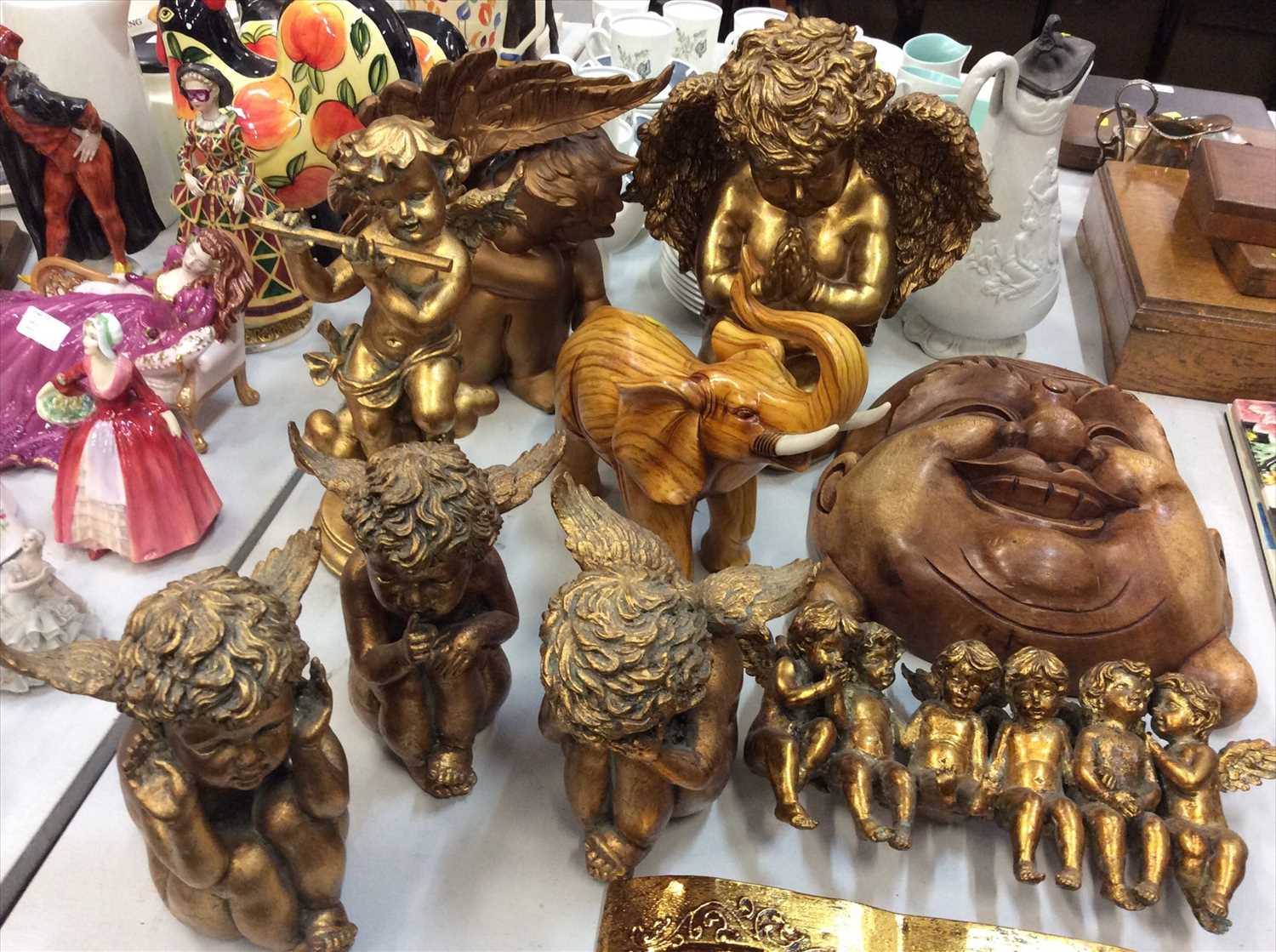 Lot 461 - Gilt Cupid ornaments, large wooden Buddha mask and a wooden elephant ornament