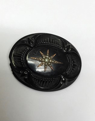 Lot 153 - Victorian gold and black enamel mourning locket 'In Memory Of My Dear Mother', together with a Victorian carved jet brooch with seed pearl star motif