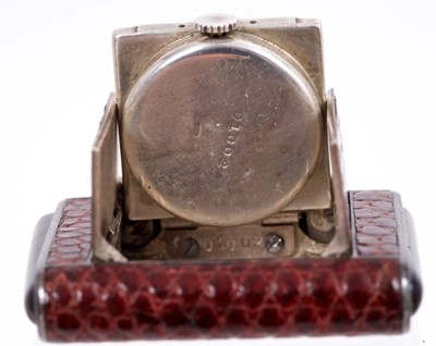 Lot 175 - 1930s Art Deco Tavannes travelling watch in snakeskin covered silver cased this end pushers to open the trap door revealing folding silvered dial signed 'Tavannes La Captive' Swiss silver marks