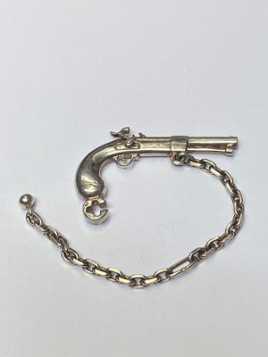 Lot 176 - Rare Dunhill silver novelty key ring in the form of a percussion pistol with chain. Stamped Dunhill, Continental hallmarks. Pistol measures approximately 47mm, chain measures 105mm.
