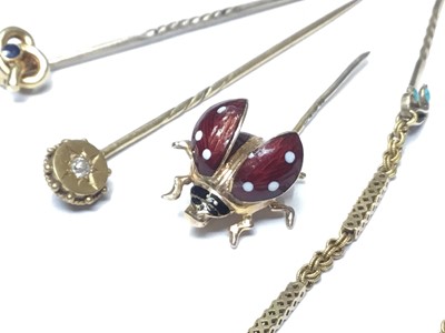 Lot 177 - Group of four gold stick pins to include a novelty 9ct gold and enamel flying ladybird stickpin, and three Victorian gold stick pins