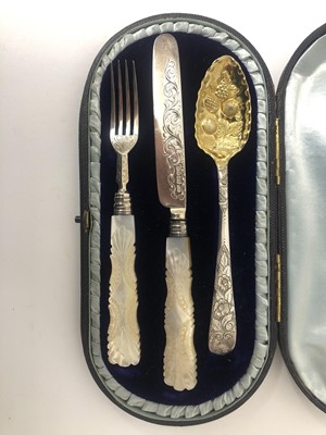 Lot 190 - A Georgian and early Victorian three piece silver christening set, the George III spoon with engraved foliate handle and gilded embossed berry bowl (marks indistinct), the Victorian silver knife an...
