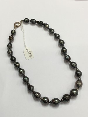 Lot 209 - Cultured Tahitian baroque black/grey pearl necklace with a single string of slightly graduated cultured pearls measuring approximately 10-13mm diameter on a silver clasp