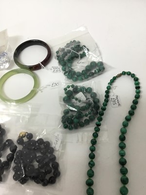 Lot 219 - Group of necklaces to include malachite bead necklaces, amber necklaces, two greenstone bangles and others