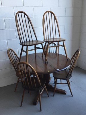 Lot 28 - Ercol 'Golden Dawn' extending dining table of circular form, together with six Ercol stick back dining chairs