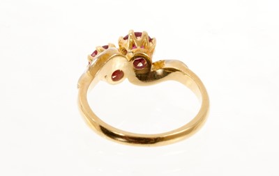 Lot 436 - 18ct gold two ruby cross over stone ring decorated with chip diamonds on flank