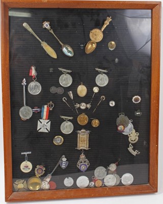 Lot 767 - Group of silver and plated fobs together with medals and other items mounted in a glazed frame