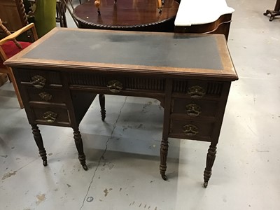 Lot 931 - Edwardian oak kneehole desk with lined top,five drawers with ornate brass handles on fluted taper legs