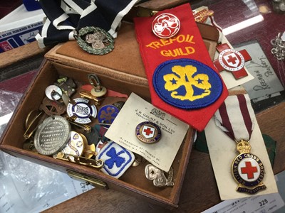 Lot 298 - Box of Girl Guides and Red Cross badges, including silver and enamel