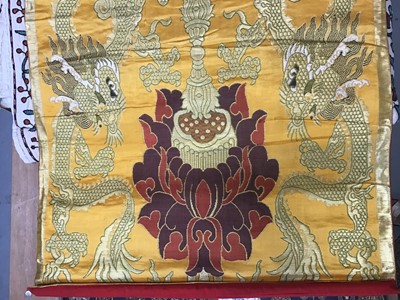 Lot 1780 - Chinese embroidered silk Dragon wall hanging plus three silk brocade dragon hangings.  Also two Tibetan Thanka   painted silk panels.