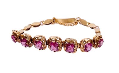 Lot 540 - Gold and garnet bracelet with seven graduated mixed cut garnets in pierced gold setting