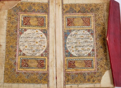 Lot 811 - Antique Quran with illuminated pages in tooled red leather binding