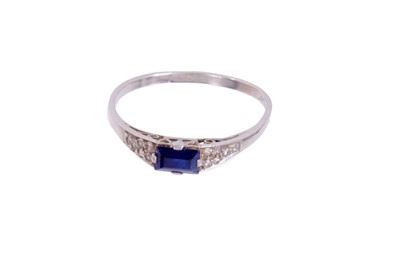 Lot 410 - Art Deco sapphire and diamond ring with a rectangular step cut blue sapphire flanked by pavé set single cut diamonds to the shoulders on platinum shank. Ring size P.