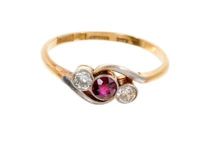 Lot 411 - Edwardian ruby and diamond three stone ring with a central round mixed cut ruby flanked by two old cut diamonds, all in platinum millegrain setting of cross-over design with platinum shoulders on 1...