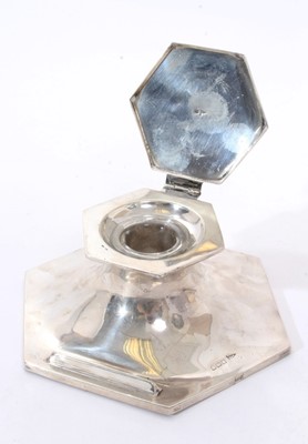 Lot 304 - George V silver capstan inkwell of hexagonal form, with  pen rest, hinged cover and clear glass ink reservoir (Sheffield 1914) Walker & Hall. Together with another inkwell of octagonal pyramid form...