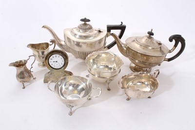 Lot 308 - Selection of early 20th century silver, including two teapots, sauce boat, two sugar bowls, two cream jugs and desk clock (Various dates and makers) Approximately 48ozs weighable silver. (qty)