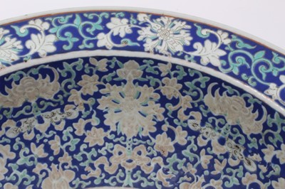Lot 122 - Large antique Chinese porcelain bowl, circa 1900, decorated with bats, fish and foliate patterns on a dark blue ground, 41cm diameter