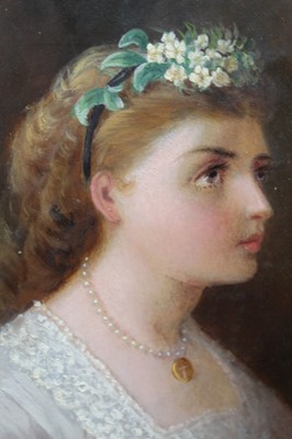 Lot 1088 - English School 19th Century, oil on card – A pretty young lady with flowers in her hair and a gold locket at her throat, oval, in gilt frame, 19.5cm x 14cm