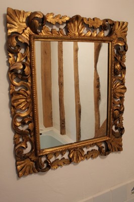 Lot 1338 - Florentine giltwood wall mirror, with rectangular plate and scrolling pierced foliate frame