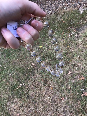 Lot 505 - Antique crystal bead necklace with 23 graduated spherical beads cased in gold wire cages on a gold clasp, 46cm
