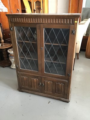 Lot 76 - Old charm style bookcase enclosed by two leaded glazed and linen fold panelled doors