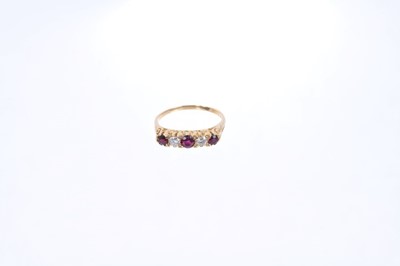 Lot 557 - Diamond and ruby five stone ring on 18ct yellow gold band