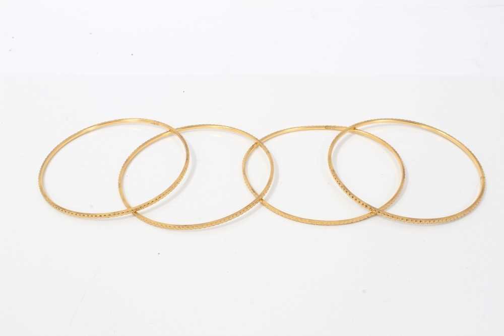 Lot 207 - Four Eastern gold bangles