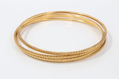 Lot 207 - Four Eastern gold bangles