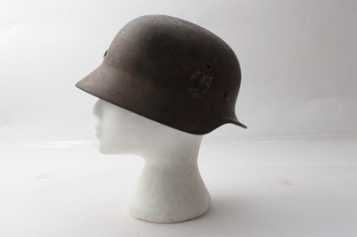 Lot 225 - Second World War Nazi M35 pattern Waffen SS steel helmet, with metal headband, leather chin strap, battle damage to the top of the helmet, painted SS insignia, named to Grohmann under the brim.