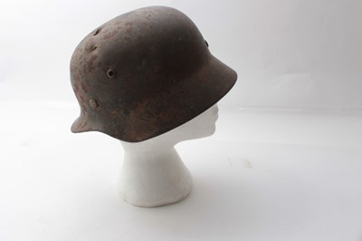 Lot 225 - Second World War Nazi M35 pattern Waffen SS steel helmet, with metal headband, leather chin strap, battle damage to the top of the helmet, painted SS insignia, named to Grohmann under the brim.