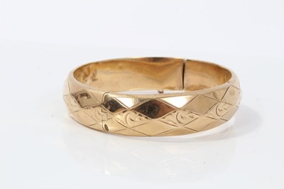 Lot 51 - 9ct gold hinge bangle with geometric and scroll decoration
