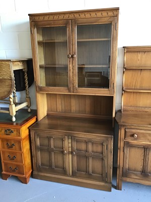 Lot 58 - Ercol elm two height bookcase with two glazed doors above enclosing two adjustable shelves, recess then two panelled doors below H196cm W98cm D49cm