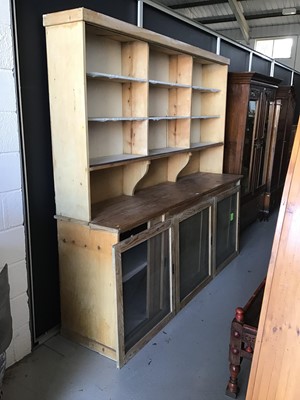 Lot 120 - Large pine kitchen dresser with fixed shelves above behind three glass sliding doors and two sliding panelled doors below