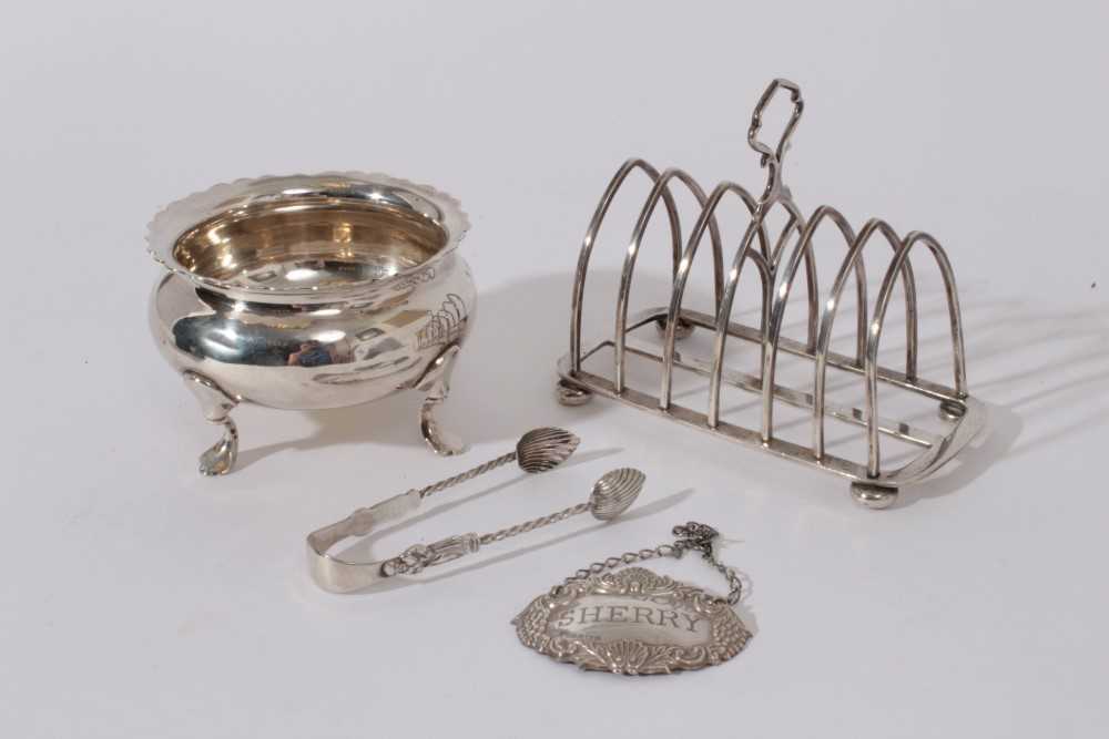 Lot 217 - George V Silver six division toast rack (Birmingham 1919) together with a silver sugar bowl raised on four hoof feet (London 1922), late Victorian silver sugar  tongs (Birmingham 1901)