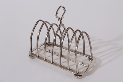 Lot 217 - George V Silver six division toast rack (Birmingham 1919) together with a silver sugar bowl raised on four hoof feet (London 1922), late Victorian silver sugar  tongs (Birmingham 1901)