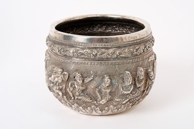 Lot 219 - Early 20th century Burmese silver bowl of circular form, with repoussé decoration of figures and Elephants, below a frieze of scroll decoration, presentation inscription to rim