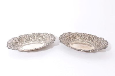 Lot 311 - Pair Victorian Silver bread dishes of oval form with ornate embossed foliate, floral and scroll decoration (London 1895) Maker, William Comyns & Sons embossed oval dishes