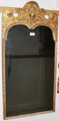 Lot 1314 - Early 18th century carved gilt wood pier mirror with original bevelled plate, putto cresting and scrolling fish-egg ground frame, 44 x 85cm