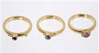 Lot 650 - Three gem set 'stacking' rings, with purple...