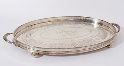 Lot 205 - George V silver gallery tray of oval form with engraved foliage decoration and two handles on four bun feet (Sheffield 1911) Walker & Hall, all at 72oz, 54cm in diameter