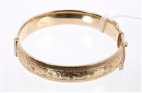 Lot 658 - 9ct gold hinged bangle with floral engraved...