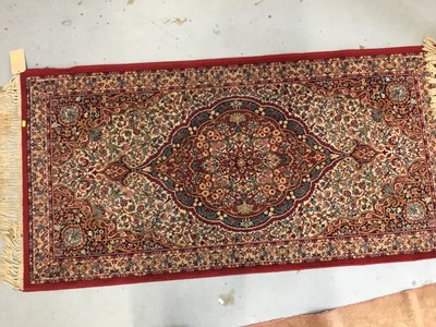 Lot 882 - Three rugs to include a Keshan rug with central medallion on red ground 180cm x 91cm, Persian rug 94cm x 55cm and a rug on pale red ground 205cm x 122cm